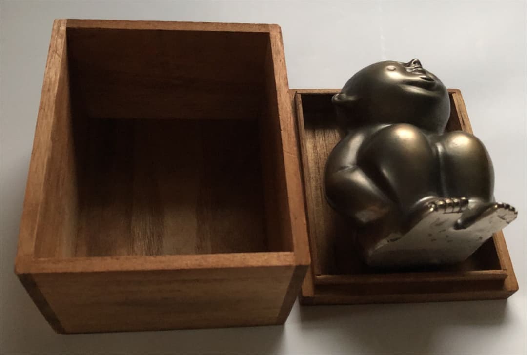 金属製　しゃがみ込むエクボのある子供像　箱付き