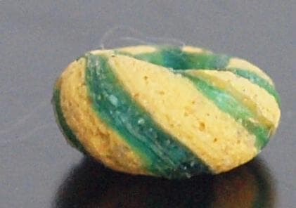 クリアな青緑に鮮やか黄で、回転する輪状モチーフを描くモザイク平玉　前後～6C頃の