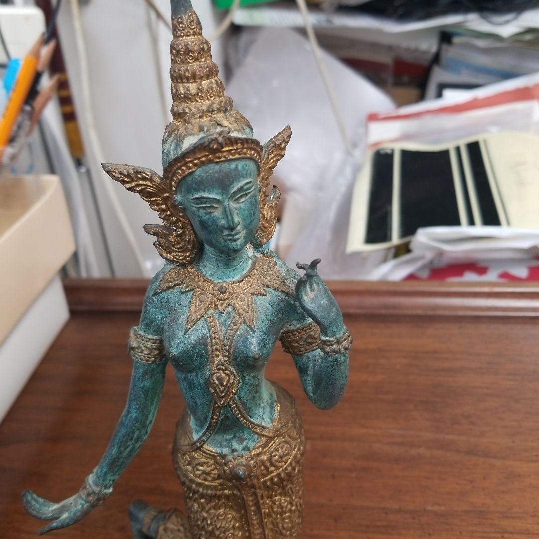 青銅色と金色のアジアの立像