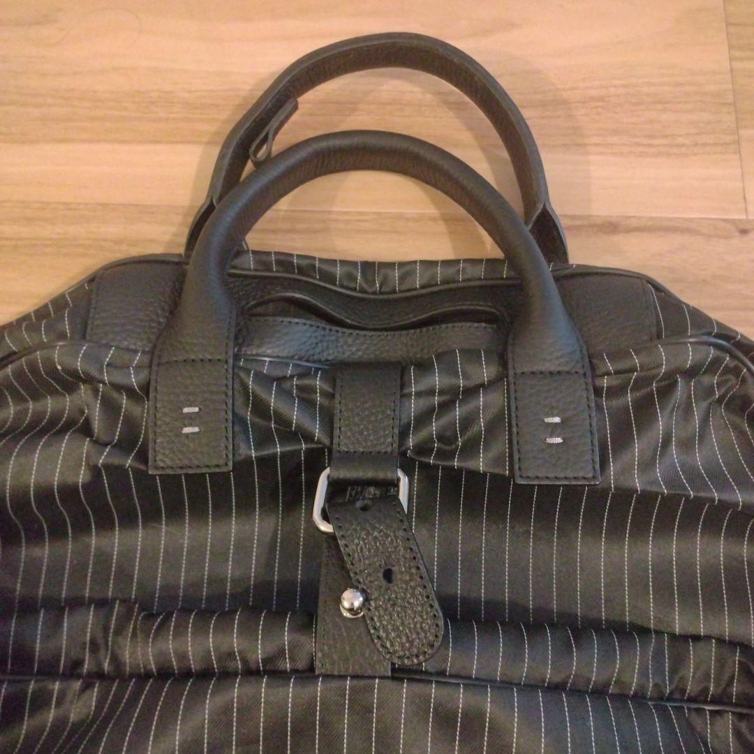 ZEGNA ストライプデザインの黒色ガーメントケース、レザー製ハンドル付き。