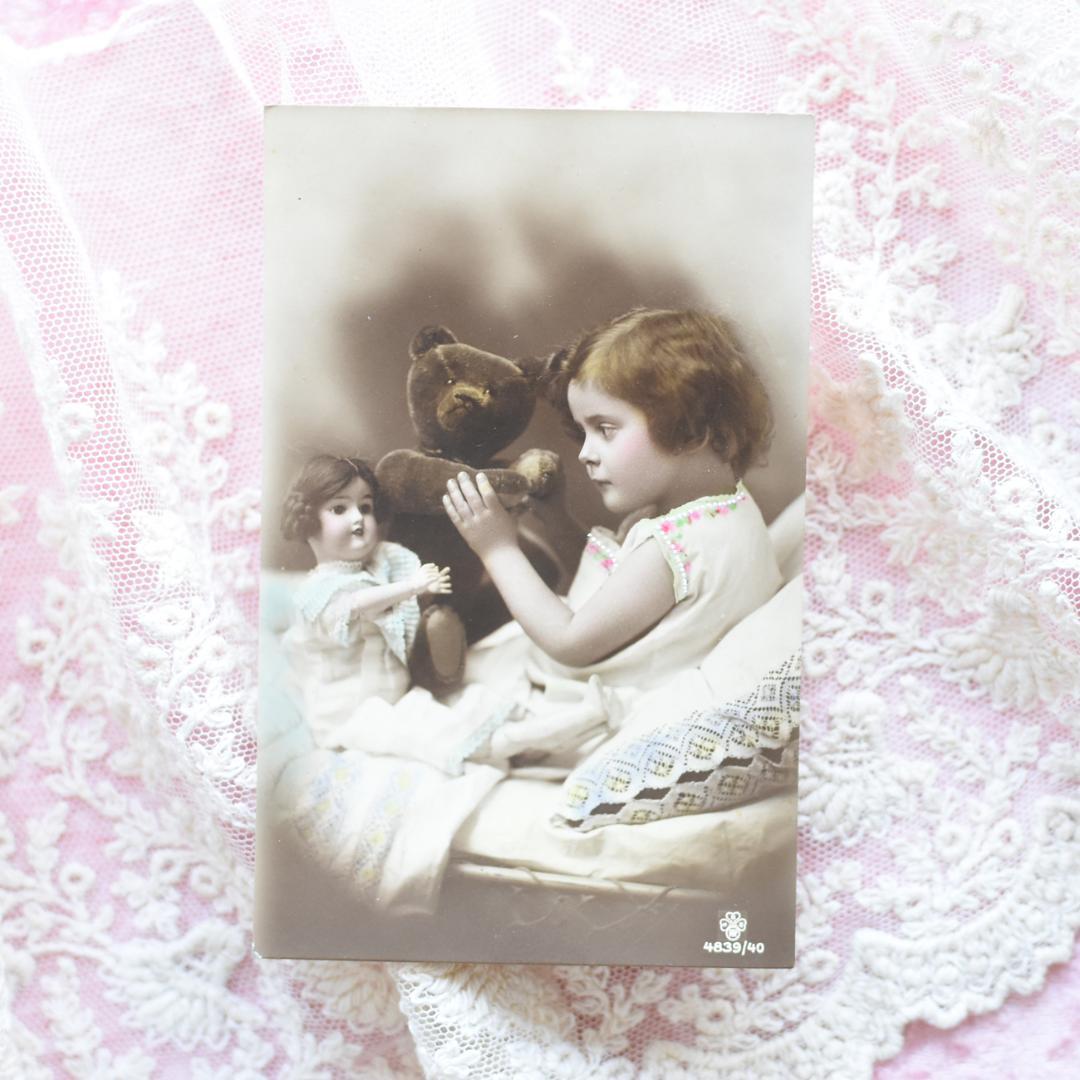 アンティークポストカード　お人形とテディベアとおしゃべりの可愛い少女　1912年