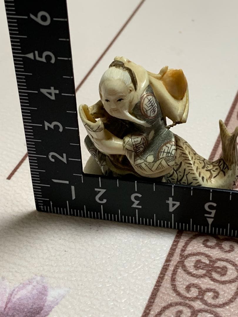 天然素材根付けアンティーク品寿老人と魚彫ってます。
