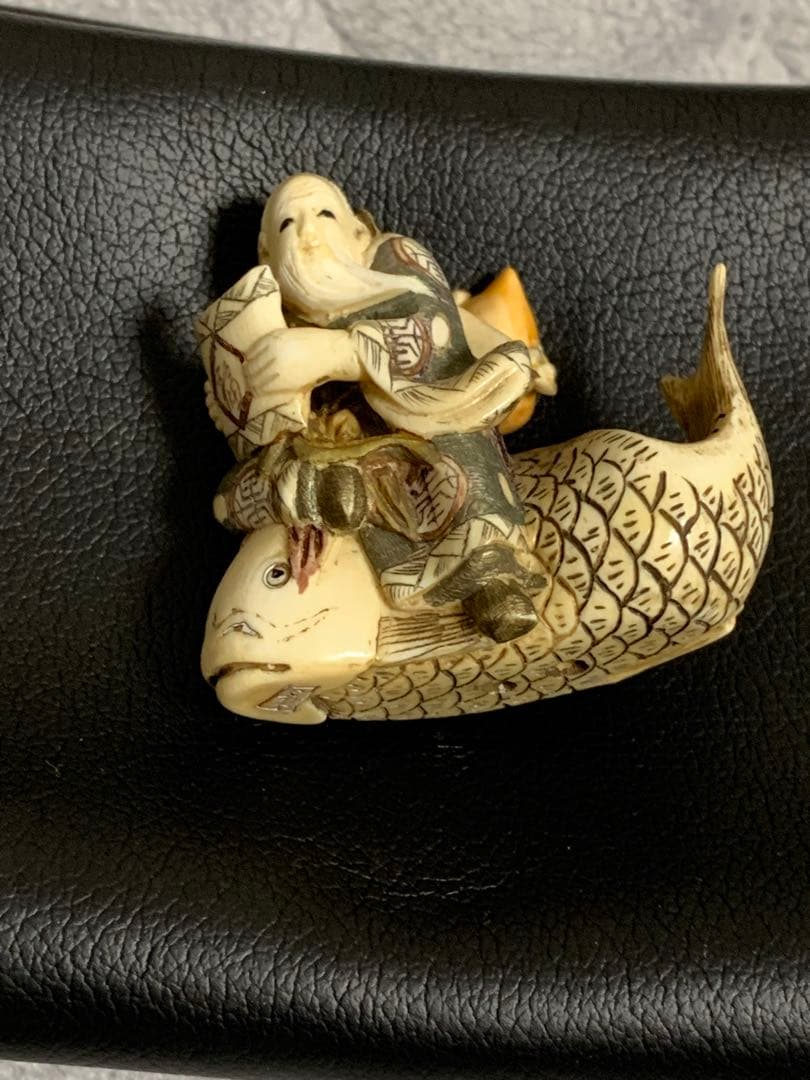 天然素材根付けアンティーク品寿老人と魚彫ってます。