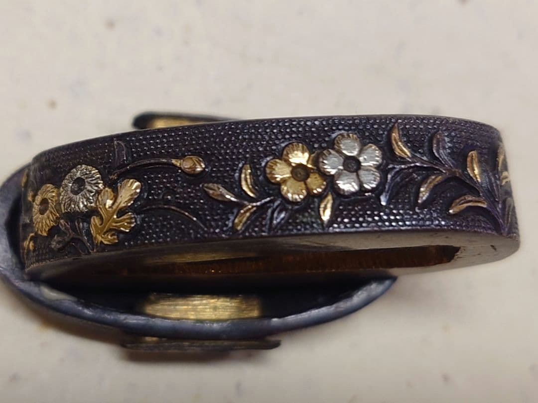 縁頭、赤銅魚子地に秋草に鶉図