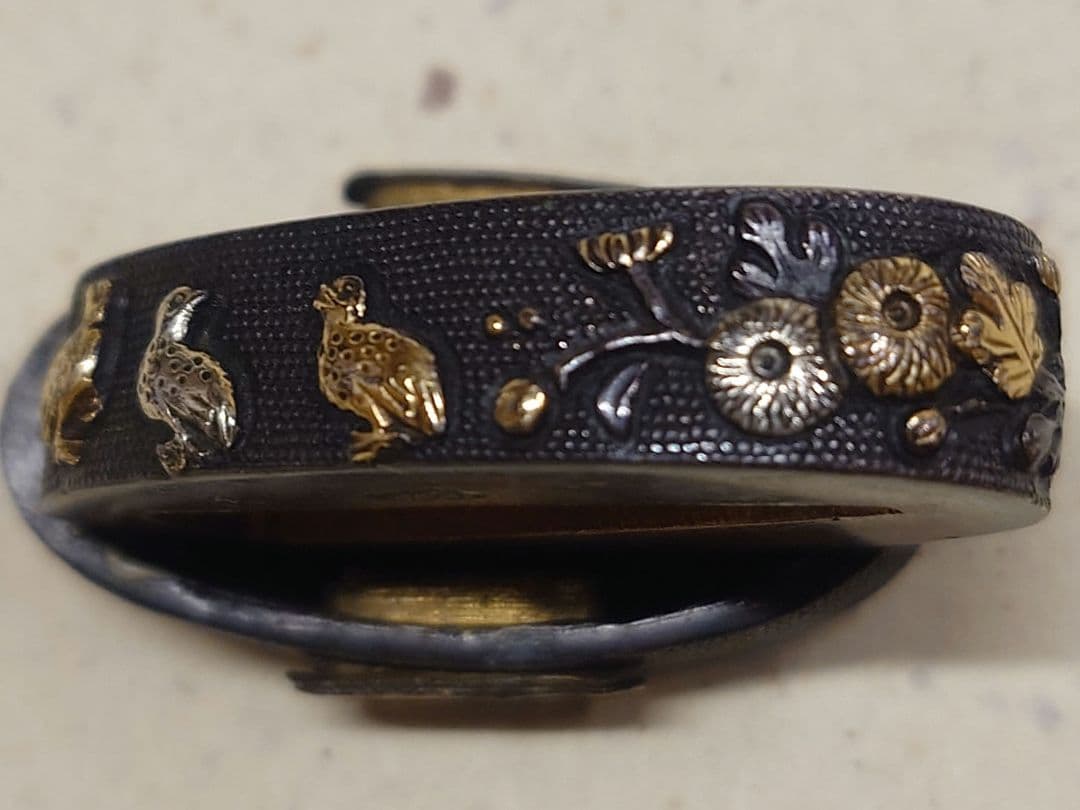 縁頭、赤銅魚子地に秋草に鶉図