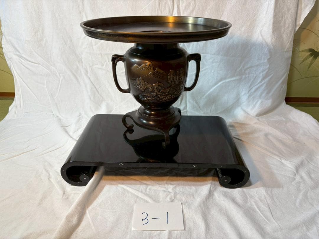 金属製花瓶と黒色巻き角台