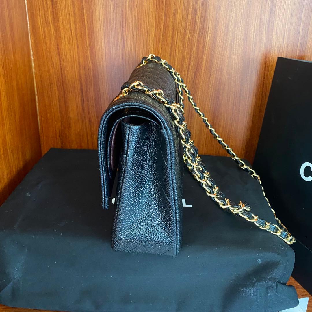 ブラックレザーのキルティングデザイン、ゴールドチェーン付きのショルダーバッグ。