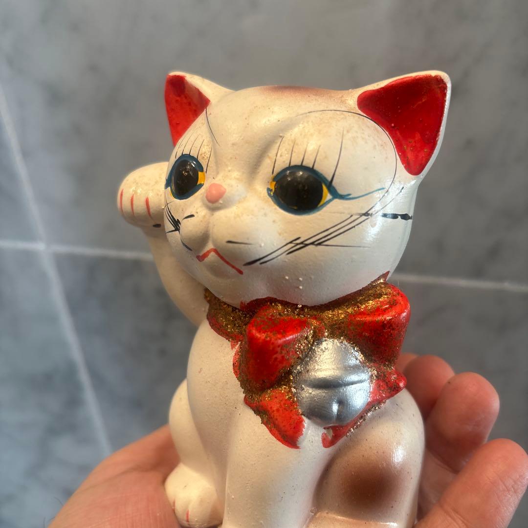 アンティーク大きな瞳や長いヒゲ、まつ毛が美しく、大きなリボンも可愛い招き猫