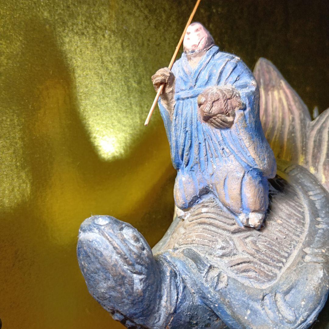 亀の上に立つ人物像 置物